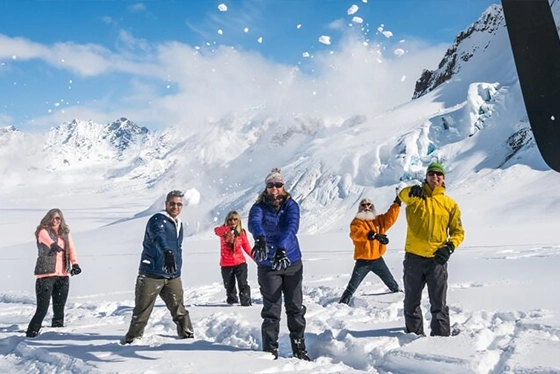 Group of People Enjoying Snowball Fight on Snowy Mountain Tour