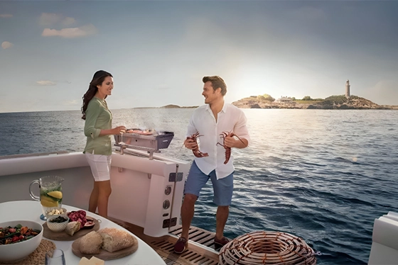 Couple Grilling Lobsters on a Luxury Yacht at Sunset, Travel Agency Ohio