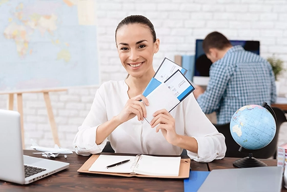 Smiling Woman Holding Travel Tickets at an Ohio Travel Agency Desk