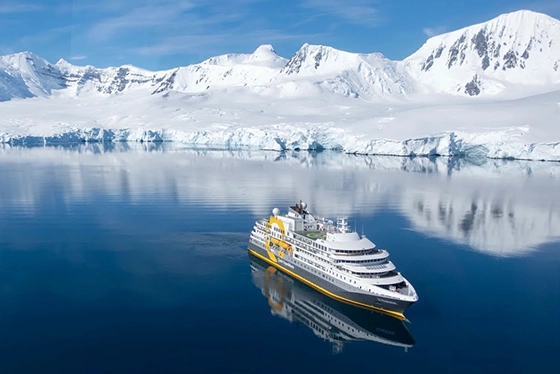 Cruise Ship Navigating Icy Waters Near Snow-Capped Mountains