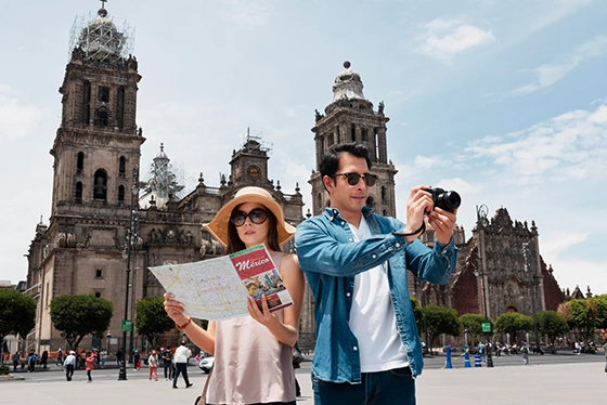 Tourists Exploring Historic Plaza in Mexico City with a Map and Camera