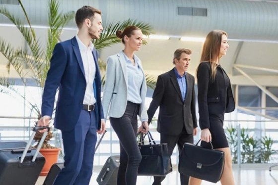 Business Professionals Walking Through an Airport Terminal, Luggage in Hand
